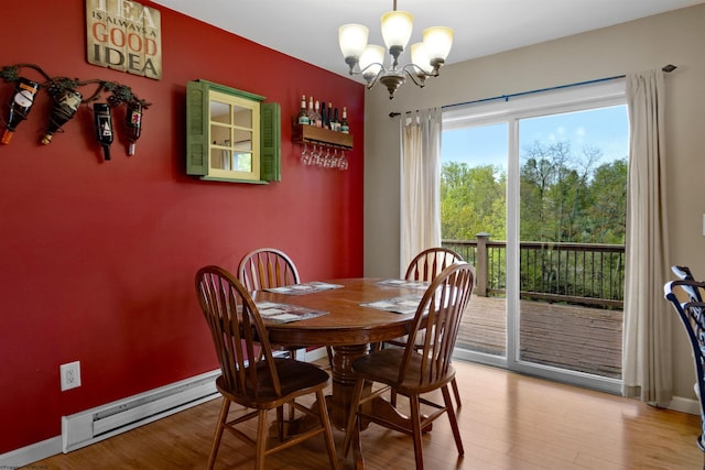 dining area with baseboards, a notable chandelier, baseboard heating, and light wood finished floors