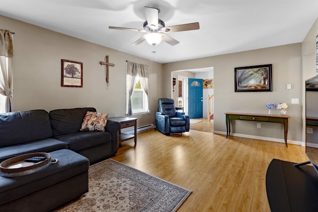 living room featuring a ceiling fan, baseboards, baseboard heating, and light wood-type flooring