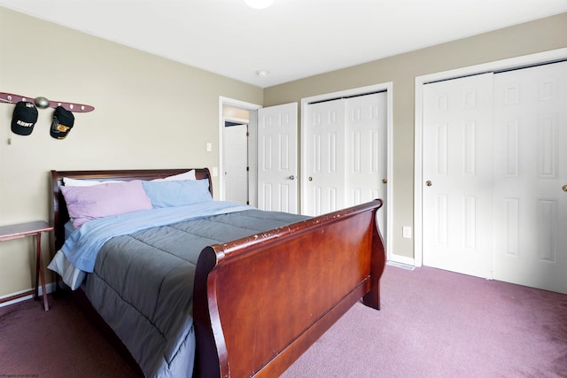 carpeted bedroom featuring baseboards and multiple closets