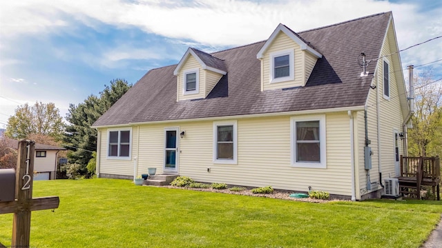cape cod home with a shingled roof, a front lawn, and ac unit