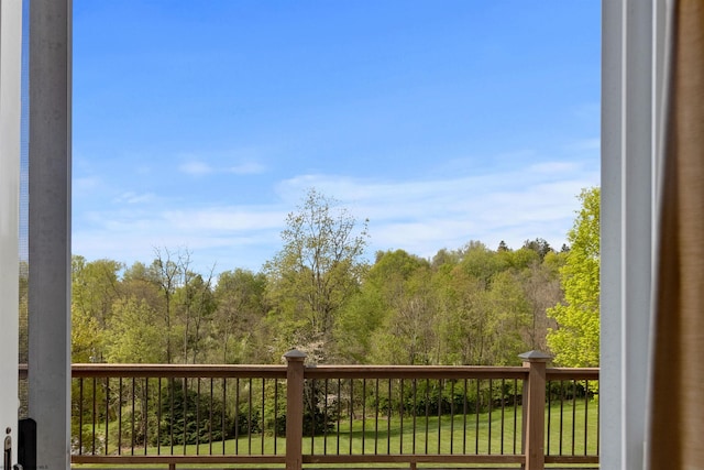 exterior space featuring a lawn and a wooded view