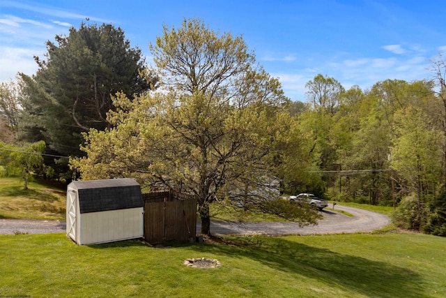 exterior space featuring an outdoor structure, a view of trees, and a shed