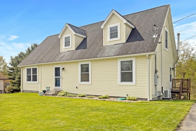 cape cod-style house with a shingled roof, ac unit, and a front yard