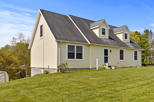 rear view of house with roof with shingles and a yard