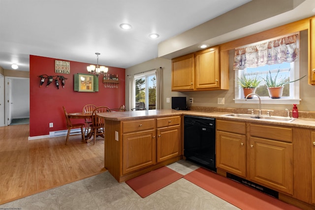 kitchen featuring dishwasher, a sink, light countertops, a peninsula, and an inviting chandelier