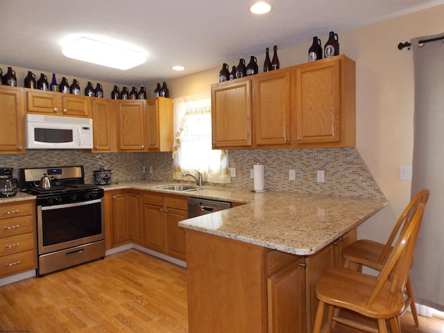 260 Donna Ave, Morgantown, WV 26505 - kitchen featuring decorative backsplash, a peninsula, light wood-style floors, a sink, and stainless steel appliances