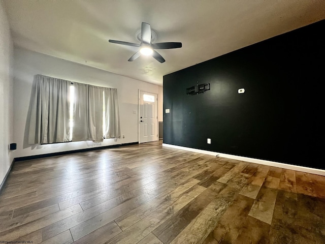 unfurnished living room featuring baseboards, ceiling fan, and hardwood / wood-style floors
