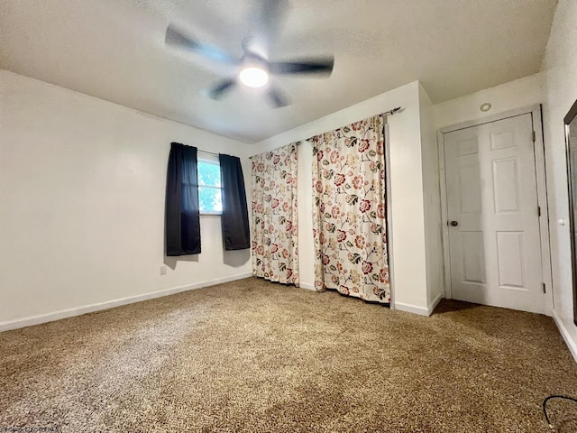 unfurnished bedroom featuring baseboards, a textured ceiling, carpet, and ceiling fan