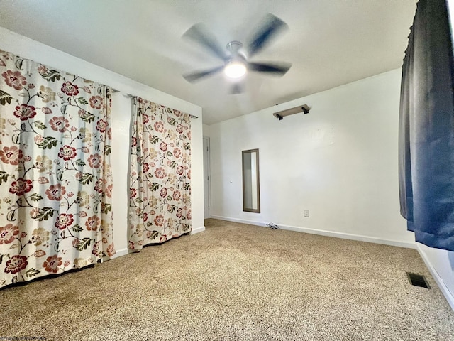 carpeted spare room featuring a ceiling fan, baseboards, and visible vents