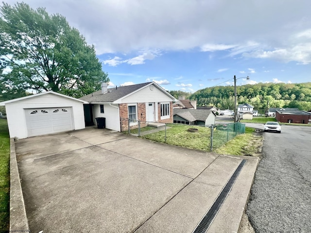 view of front of home with fence, concrete driveway, a front lawn, and brick siding
