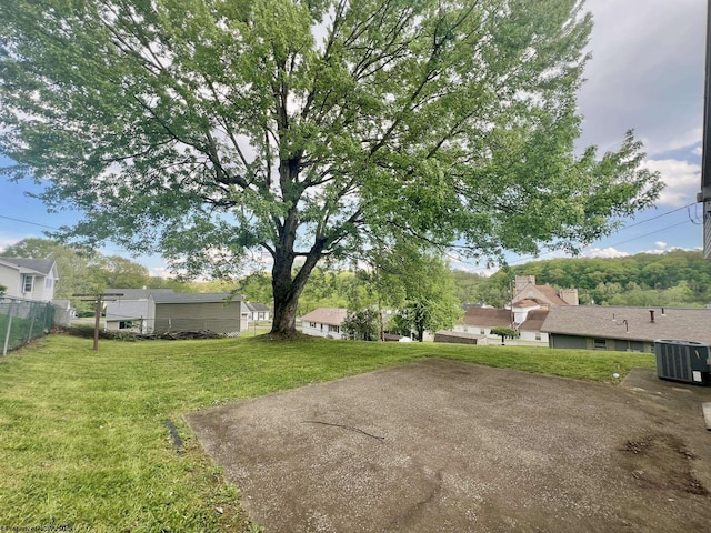 view of yard with central air condition unit and fence