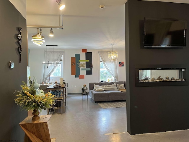 living area featuring rail lighting, a chandelier, and a wealth of natural light