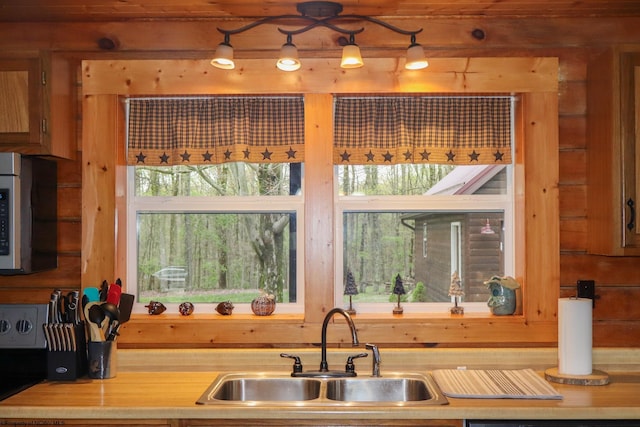 kitchen with a sink, stainless steel microwave, and light countertops