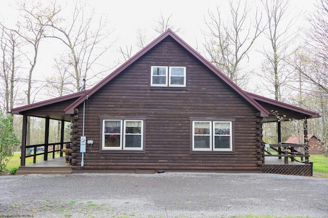 view of side of property featuring a porch and log exterior