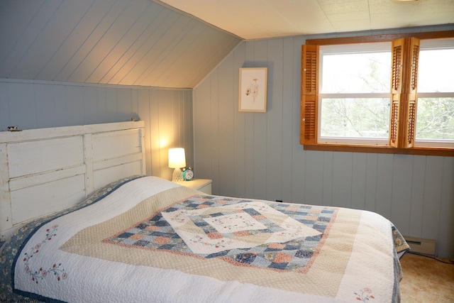 carpeted bedroom with lofted ceiling and a baseboard radiator