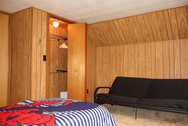 carpeted bedroom featuring wood walls