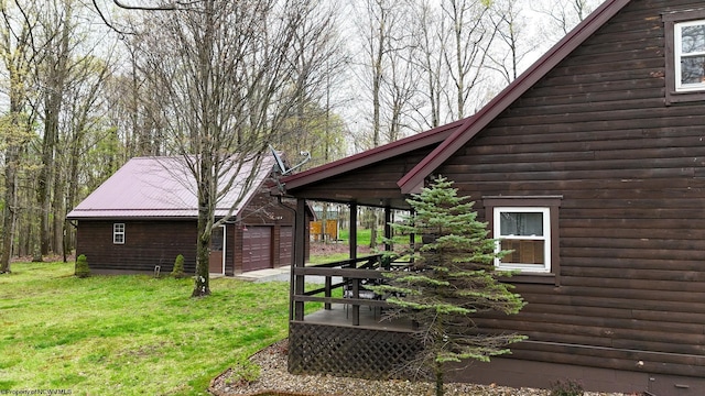 view of home's exterior featuring a yard, an outdoor structure, a wooden deck, and a garage