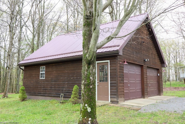 view of home's exterior featuring an outbuilding, metal roof, and a garage