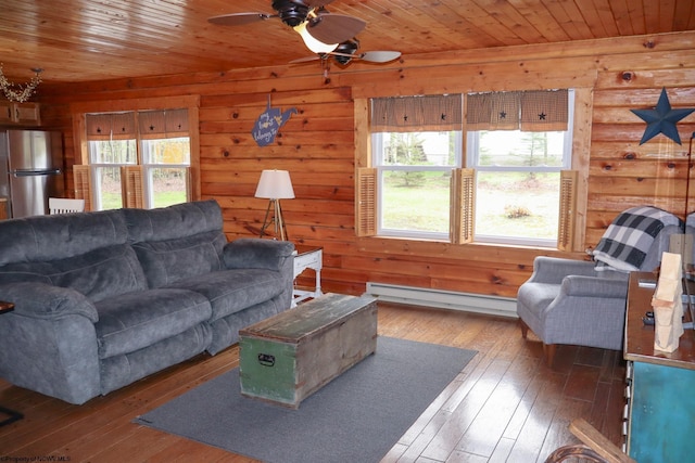 living area featuring a baseboard heating unit, hardwood / wood-style floors, a ceiling fan, and wooden ceiling