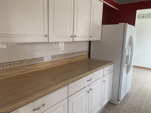 108 4th St, Spelter, WV 26438 - kitchen featuring white cabinetry, white fridge with ice dispenser, and backsplash