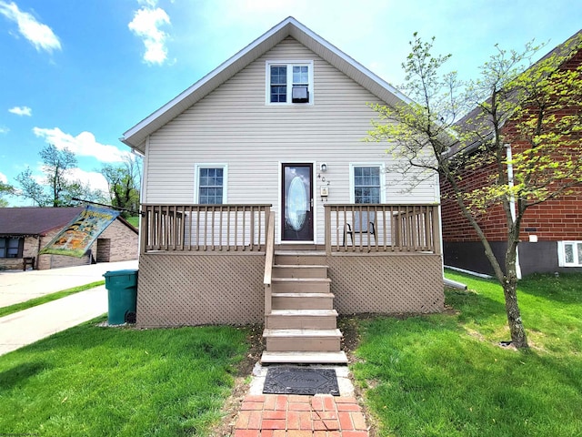 back of property featuring a wooden deck and a lawn