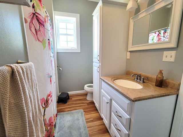 full bathroom with toilet, wood finished floors, vanity, a shower with shower curtain, and baseboards