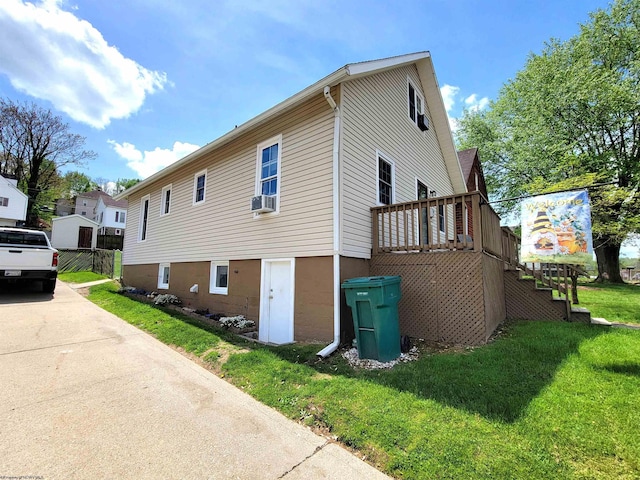 view of property exterior with a yard, a deck, cooling unit, and stairway