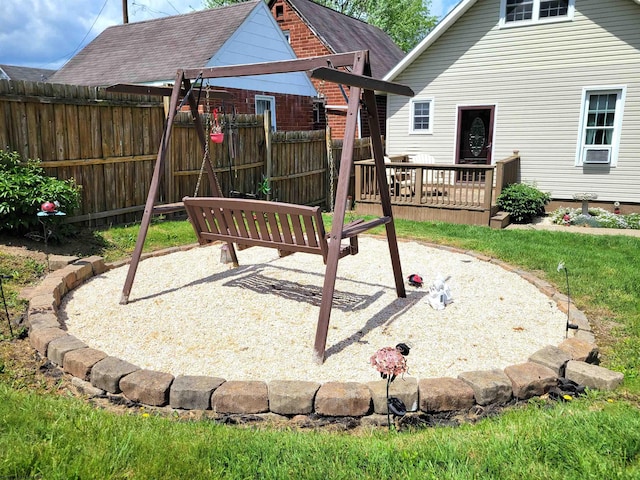 view of playground with a wooden deck and fence