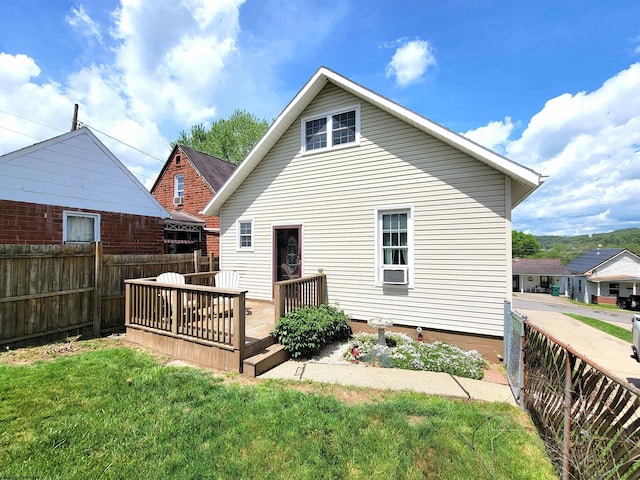 back of property with a yard, fence, and a wooden deck