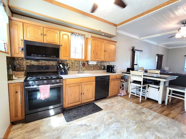 kitchen featuring a sink, stainless steel appliances, ceiling fan, light countertops, and decorative backsplash