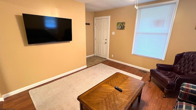 living area with dark wood-style flooring, baseboards, and visible vents