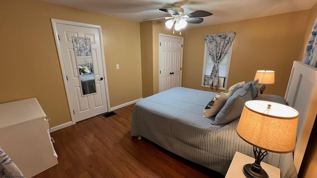 bedroom with baseboards, ceiling fan, visible vents, and wood finished floors