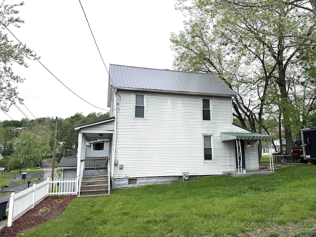back of house featuring a yard, fence, and metal roof