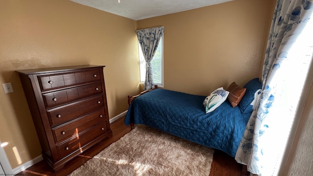 bedroom with baseboards and dark wood finished floors