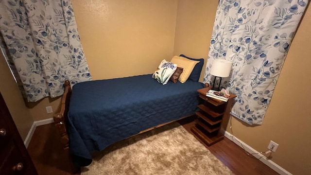 bedroom featuring baseboards and wood finished floors