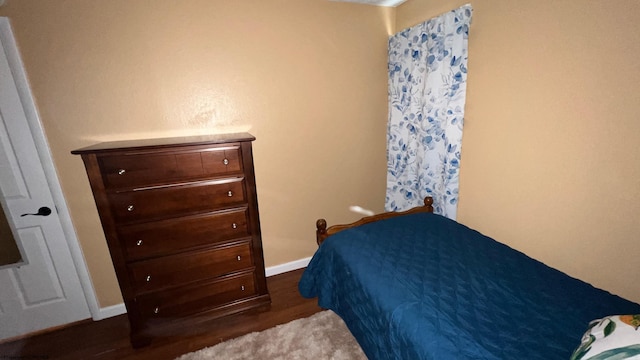 bedroom featuring baseboards and wood finished floors
