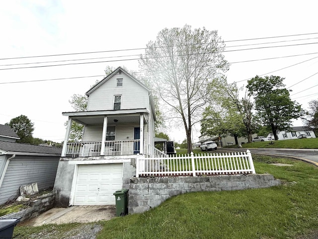 view of front facade with covered porch, driveway, an attached garage, and a front yard