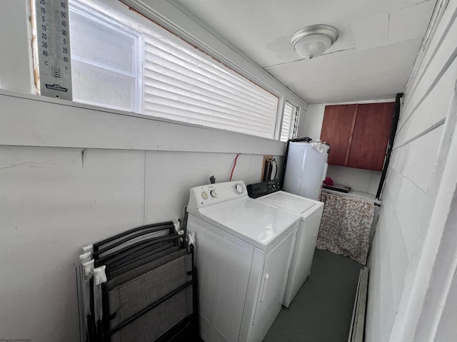 clothes washing area featuring separate washer and dryer, laundry area, and gas water heater