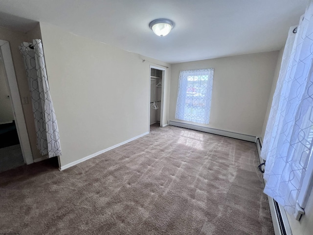 unfurnished bedroom with a closet, baseboards, baseboard heating, and carpet floors