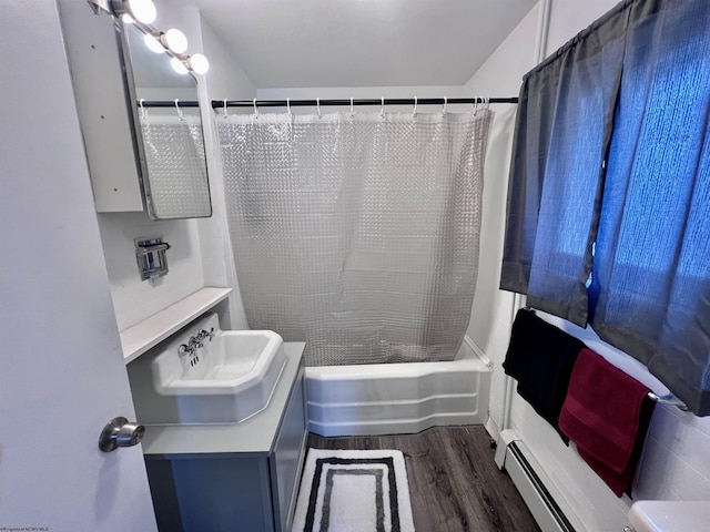 full bath featuring baseboard heating, shower / tub combo with curtain, wood finished floors, and vanity