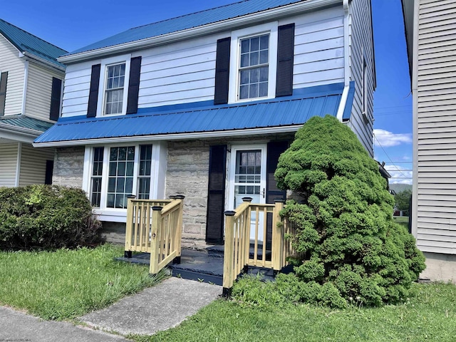 view of front of property featuring stone siding and metal roof