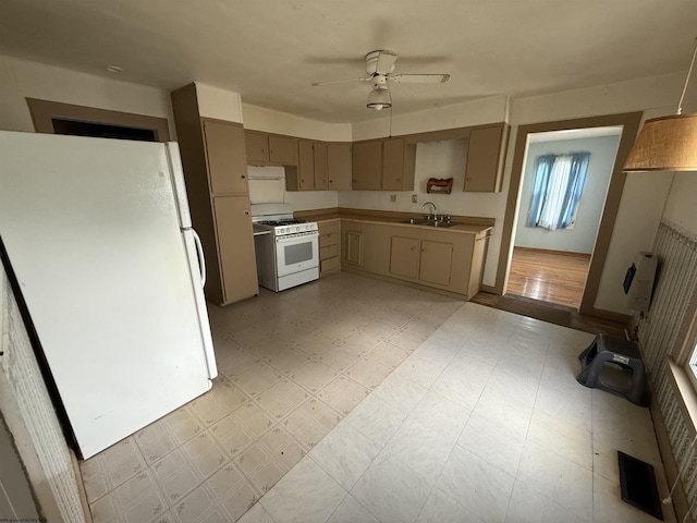 kitchen with a sink, white appliances, visible vents, ceiling fan, and light countertops