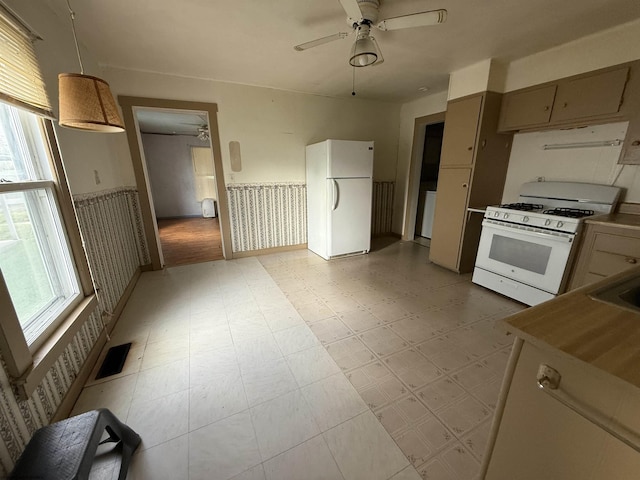 kitchen featuring light floors, white appliances, plenty of natural light, and visible vents