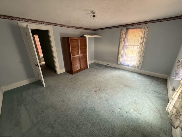 unfurnished bedroom with light colored carpet, a closet, a textured ceiling, and baseboards