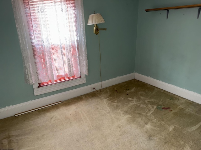 unfurnished room with carpet flooring and baseboards