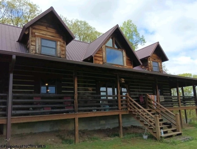 rear view of property featuring stairs, metal roof, and log siding