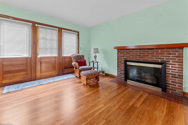 1060 Takoma St, Morgantown, WV 26505 - sitting room featuring a brick fireplace, baseboards, visible vents, and wood finished floors