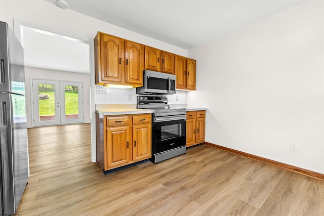 277 Randolph Rd, Morgantown, WV 26505 - kitchen featuring brown cabinetry, appliances with stainless steel finishes, light countertops, baseboards, and light wood-style floors