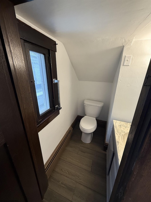 108 Marshall St, Mannington, WV 26582 - bathroom with a baseboard radiator, lofted ceiling, toilet, wood finished floors, and baseboards