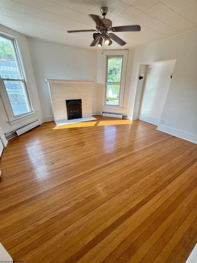 108 Marshall St, Mannington, WV 26582 - unfurnished living room with a baseboard heating unit, wood finished floors, a fireplace, ceiling fan, and baseboard heating